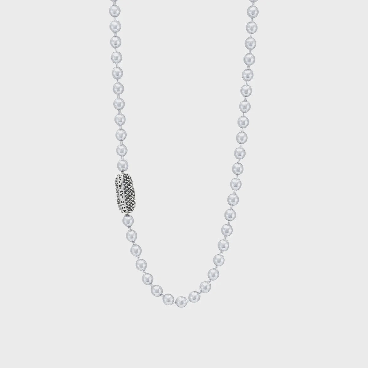 Silver ball chain necklace with textured clasp engraved Good Art HLWD on gray background