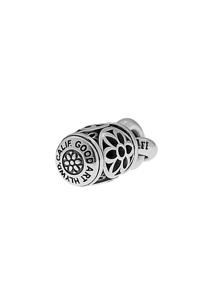 Silver Good Art Hlywd barrel pendant with intricate floral cutout design on white background