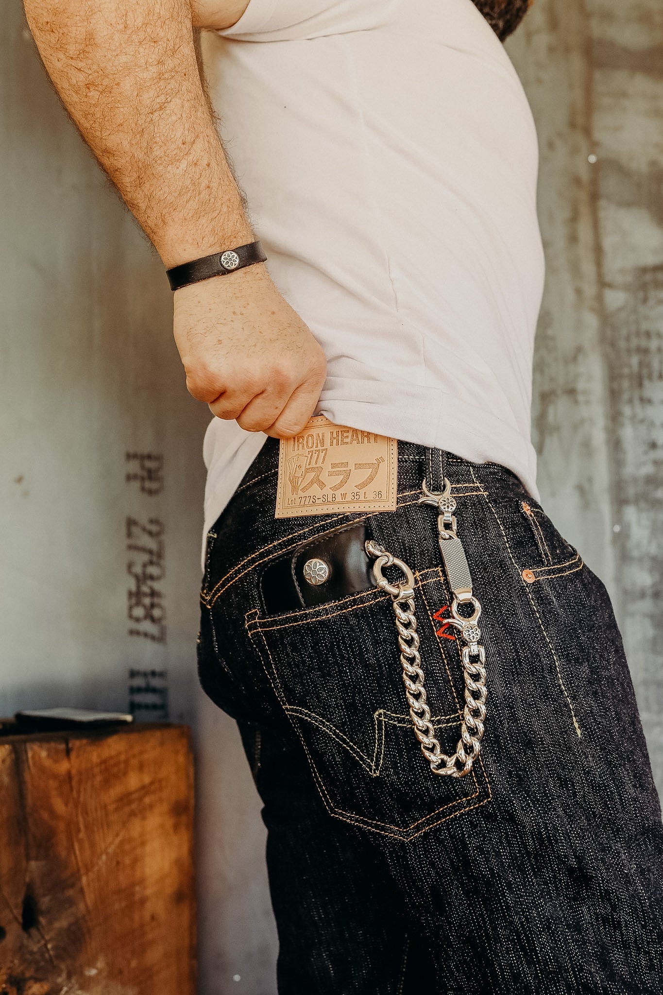 Person wearing Iron Heart 777 dark denim jeans with wallet chain and leather wristband